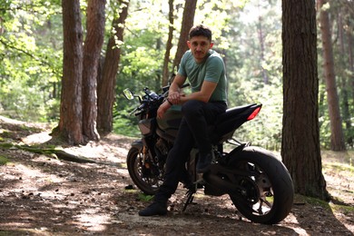 Photo of Handsome young man with modern motorcycle outdoors. Space for text