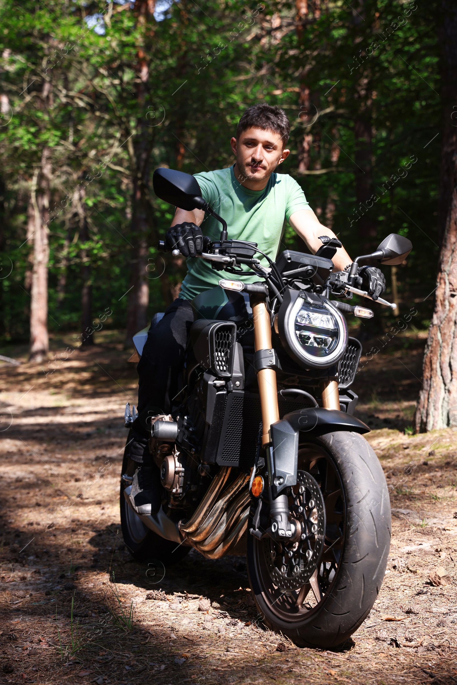 Handsome young man with modern motorcycle outdoors Photo of Handsome young man with modern motorcycle outdoors