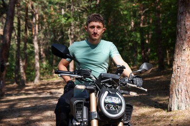 Photo of Handsome young man with modern motorcycle outdoors