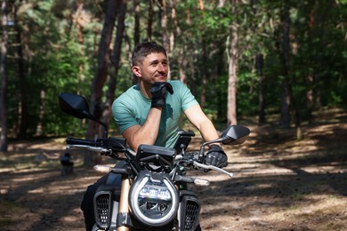 Photo of Handsome young man with modern motorcycle outdoors