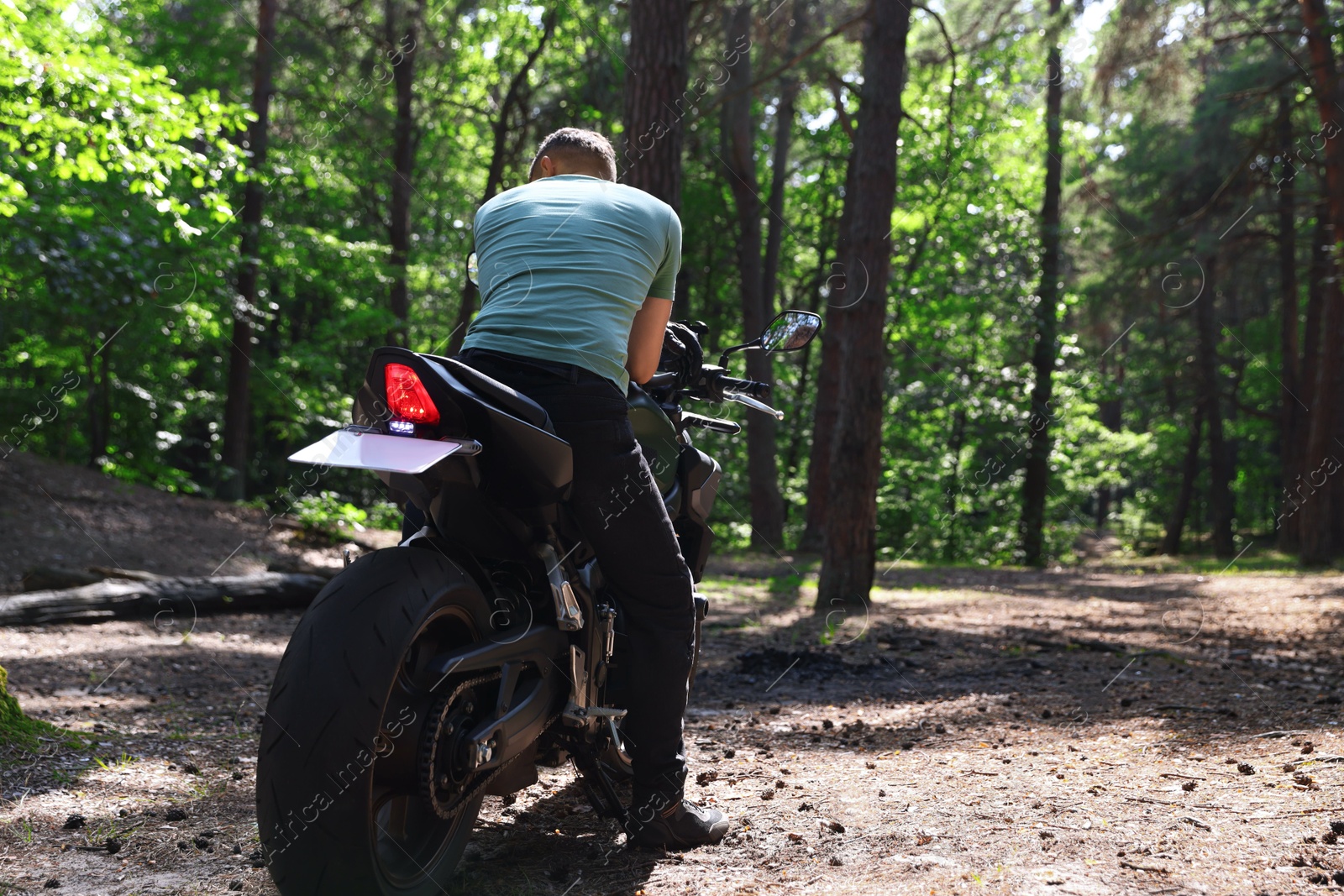 Young man with modern motorcycle outdoors, back view. Space for text Photo of Young man with modern motorcycle outdoors, back view. Space for text
