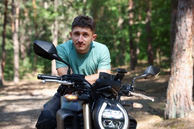 Photo of Handsome young man with modern motorcycle outdoors