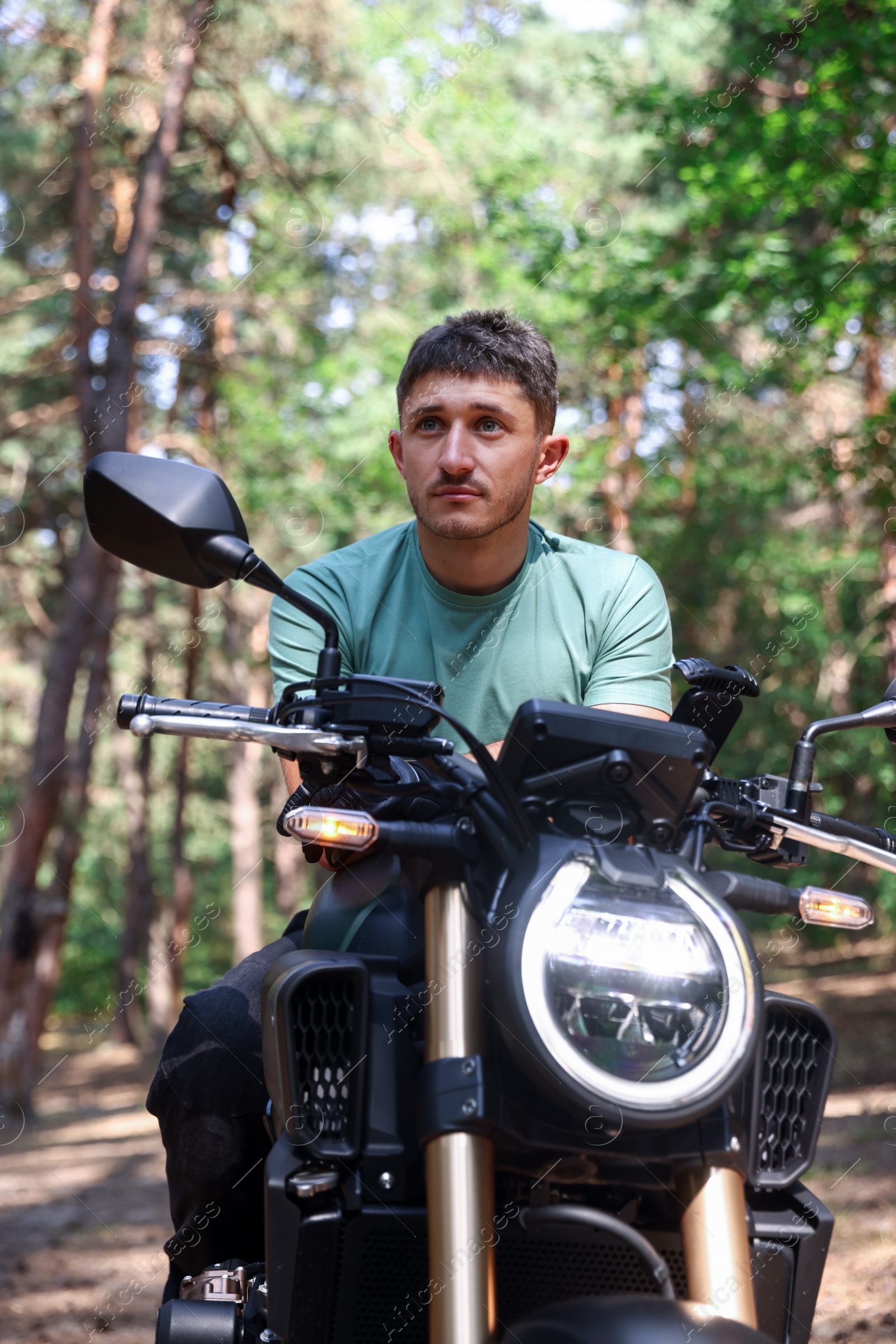 Handsome young man with modern motorcycle outdoors Photo of Handsome young man with modern motorcycle outdoors