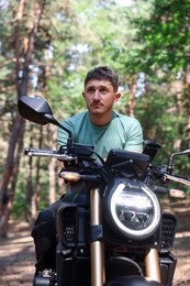 Photo of Handsome young man with modern motorcycle outdoors