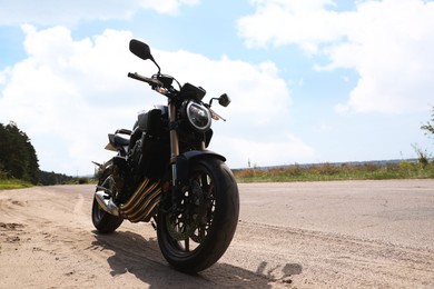 Photo of Modern black motorcycle parked near road outdoors. Space for text