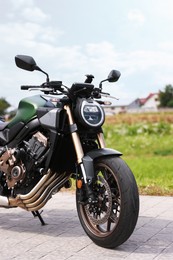 Photo of Modern black motorcycle parked on road outdoors
