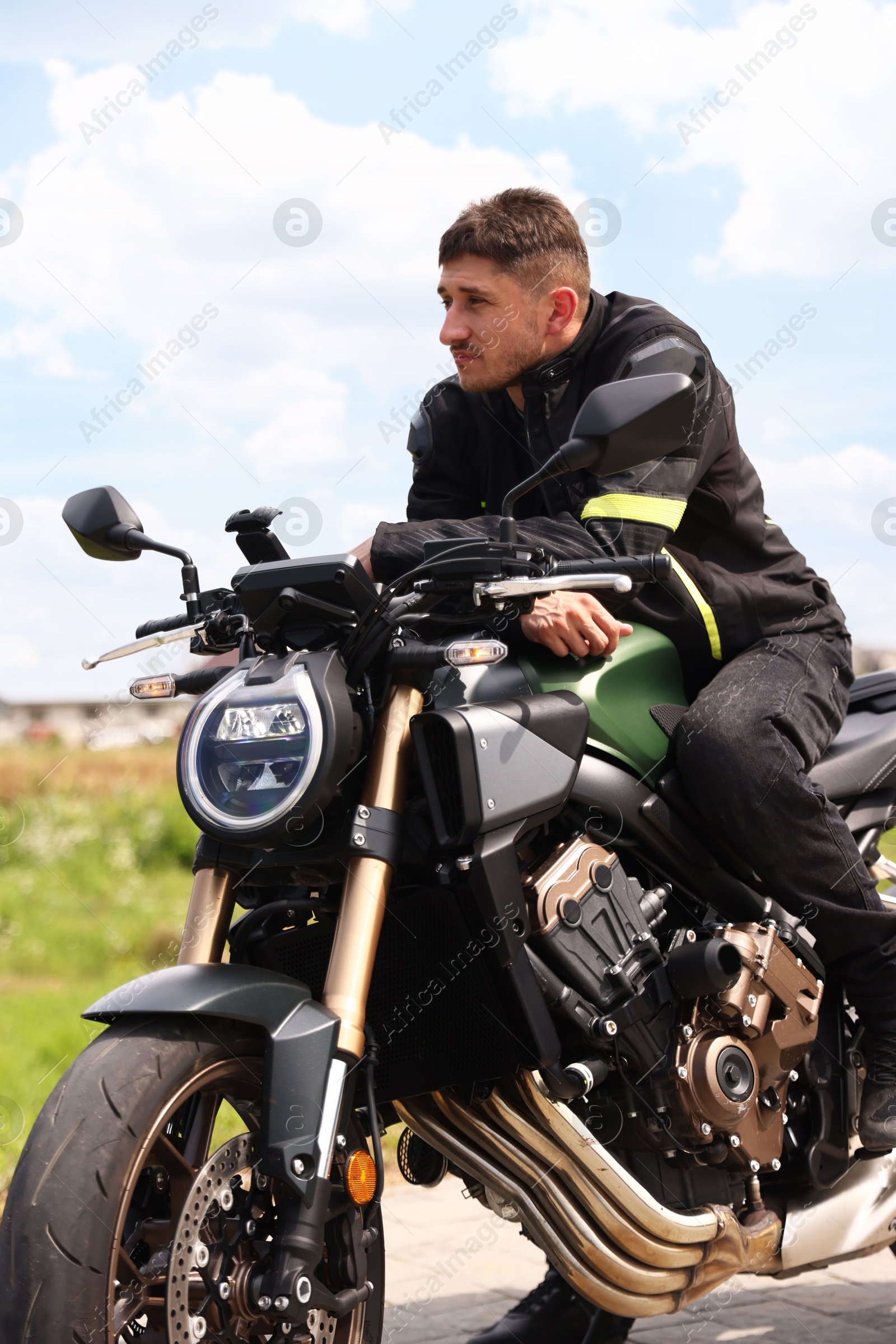 Handsome young man with modern motorcycle outdoors Photo of Handsome young man with modern motorcycle outdoors
