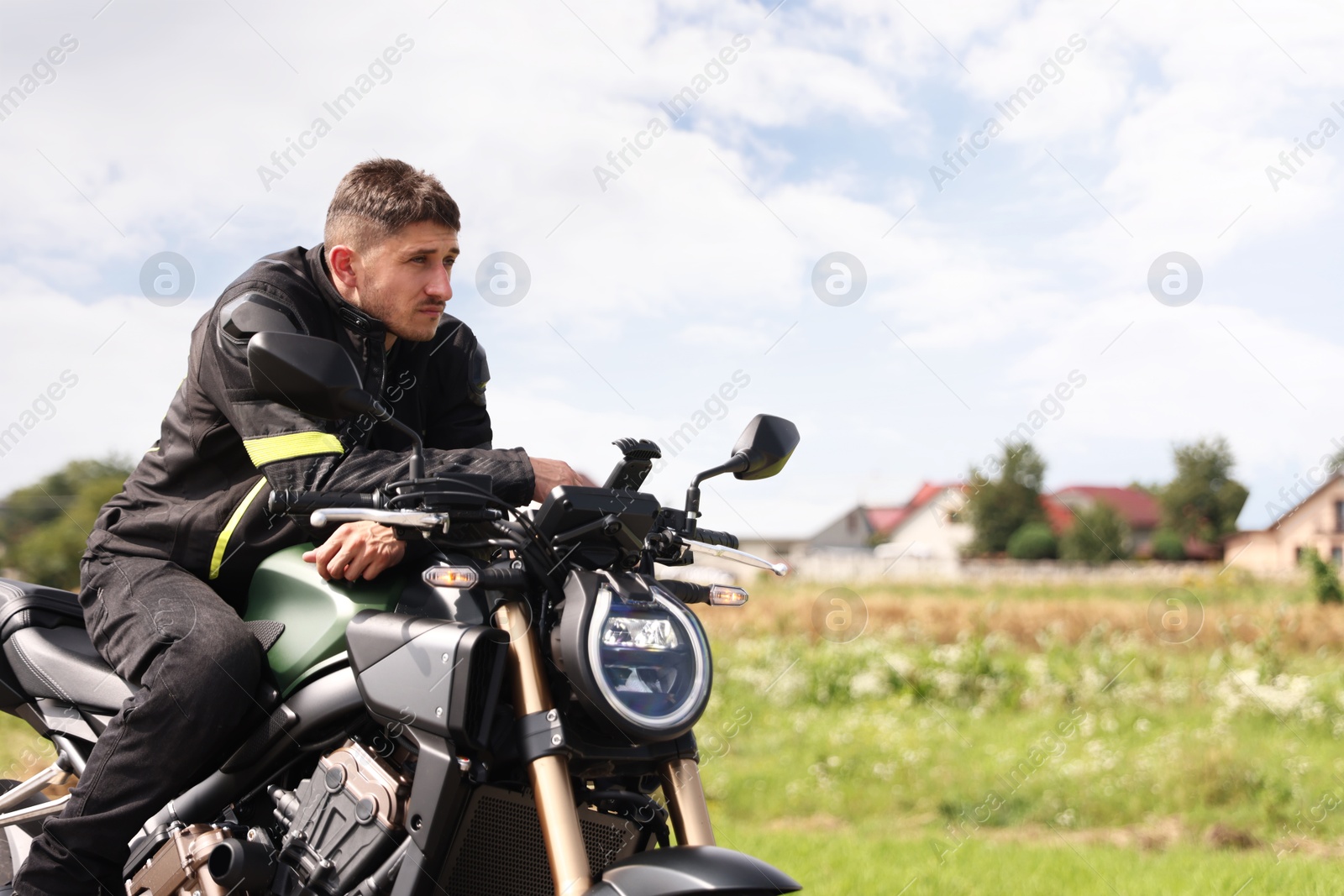 Handsome young man with modern motorcycle outdoors. Space for text Photo of Handsome young man with modern motorcycle outdoors. Space for text