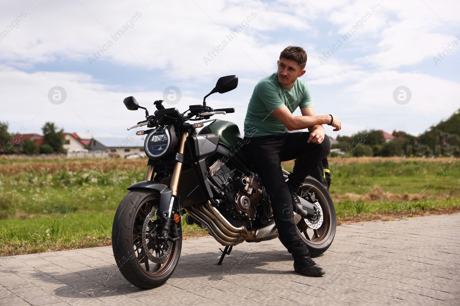 Handsome young man with modern motorcycle outdoors Photo of Handsome young man with modern motorcycle outdoors