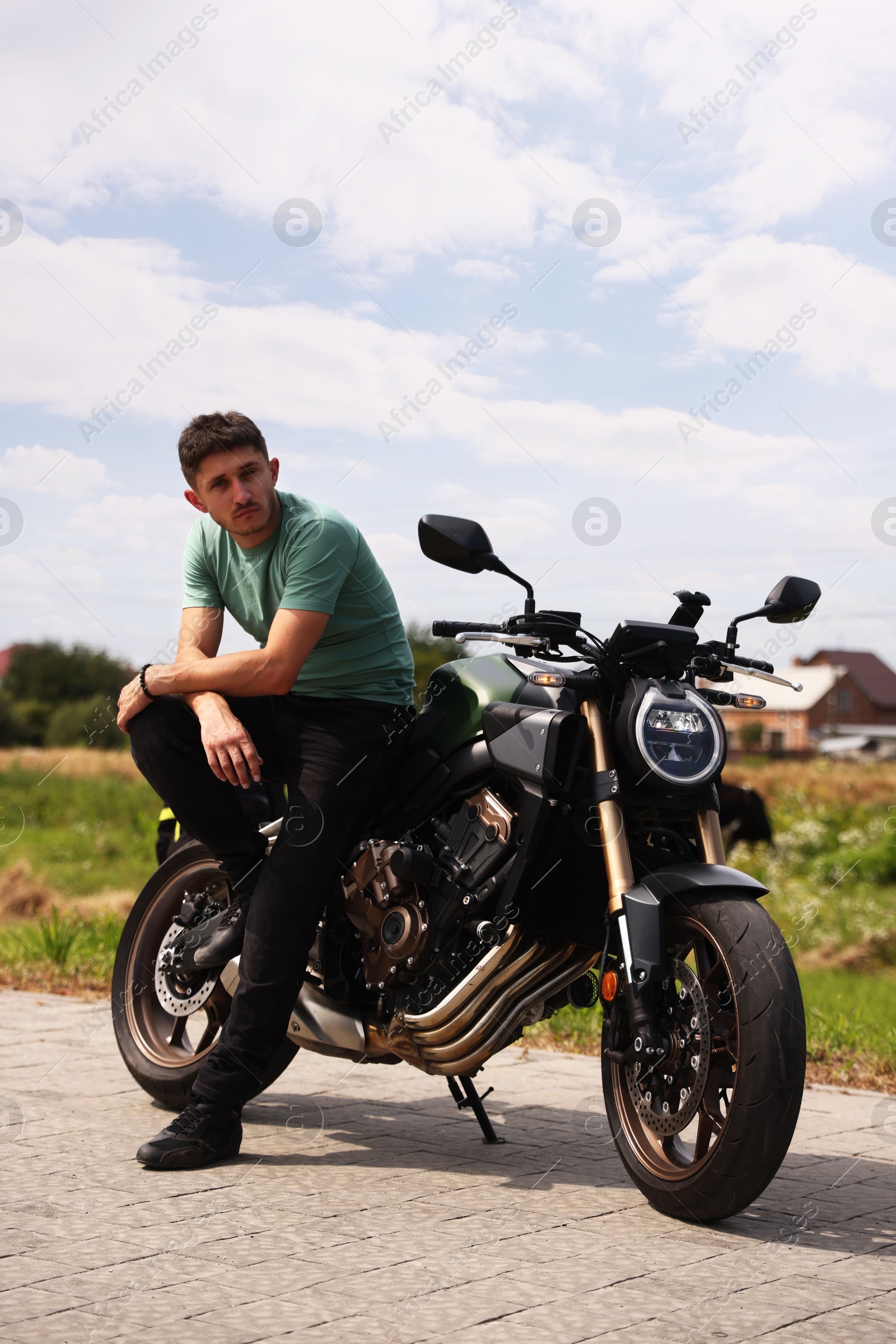 Handsome young man with modern motorcycle outdoors Photo of Handsome young man with modern motorcycle outdoors