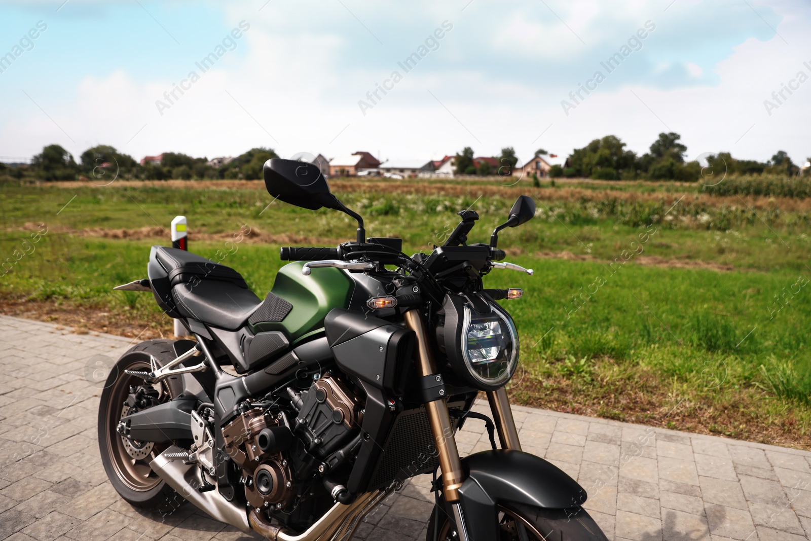 One modern black motorcycle parked near road outdoors Photo of One modern black motorcycle parked near road outdoors