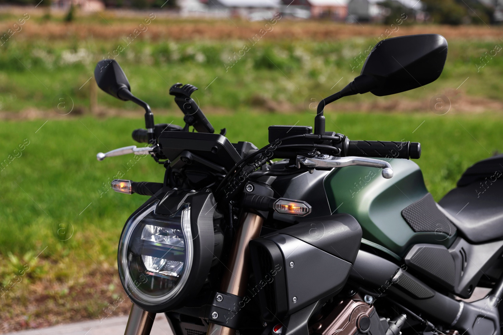 One modern black motorcycle parked near road outdoors Photo of One modern black motorcycle parked near road outdoors
