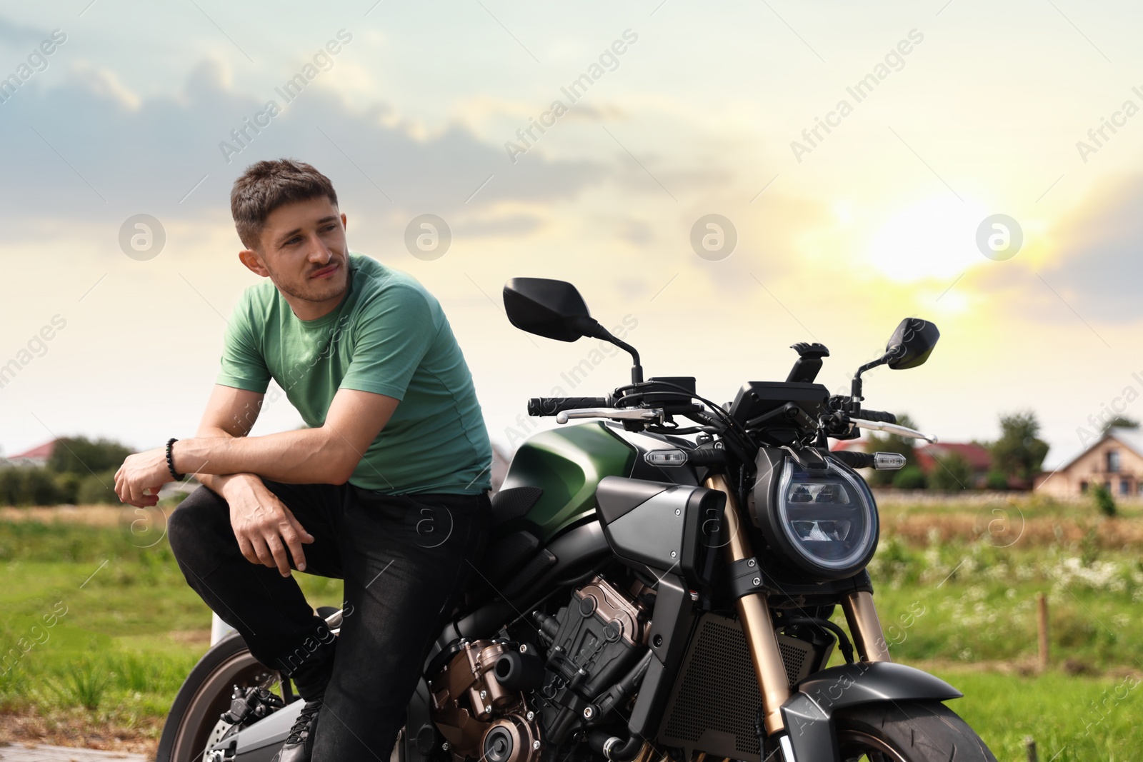 Handsome young man with modern motorcycle outdoors Photo of Handsome young man with modern motorcycle outdoors
