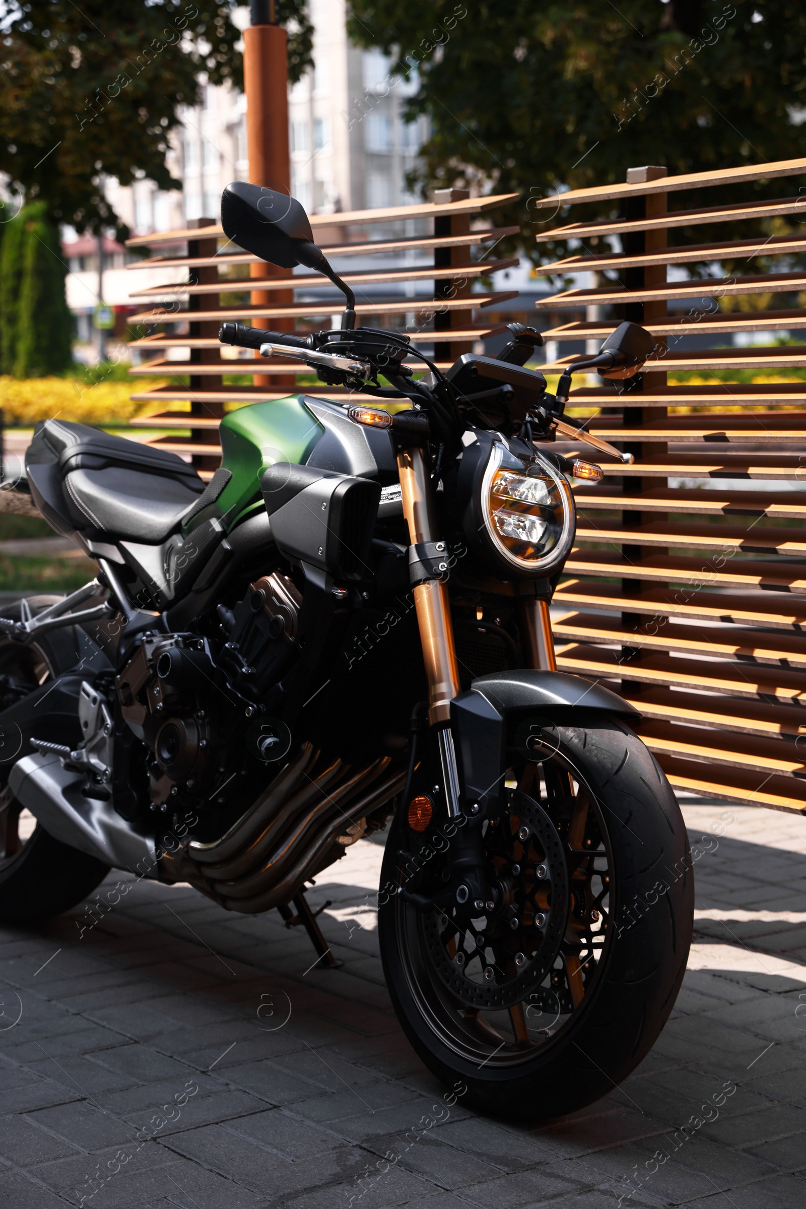 One modern black motorcycle parked near road outdoors Photo of One modern black motorcycle parked near road outdoors