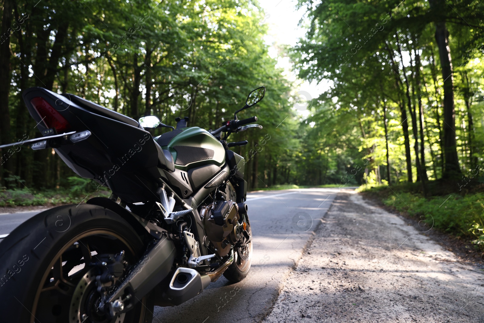Modern black motorcycle parked on road outdoors. Space for text Photo of Modern black motorcycle parked on road outdoors. Space for text