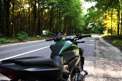 Photo of Modern black motorcycle parked on road outdoors