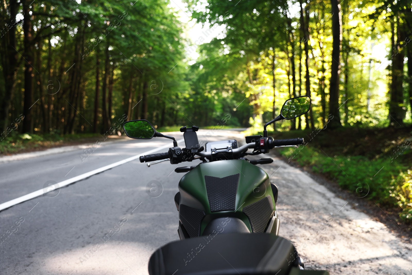 Modern black motorcycle parked on road outdoors Photo of Modern black motorcycle parked on road outdoors