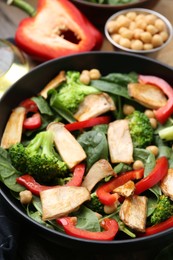 Photo of Tasty salad with eryngium mushrooms, chickpeas, vegetables and spinach in bowl on table, closeup
