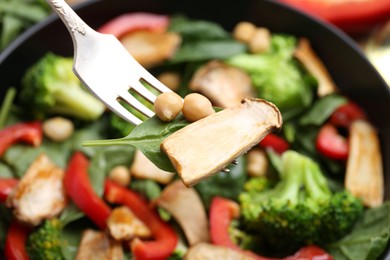Photo of Eating tasty salad with eryngium mushrooms on blurred background, closeup