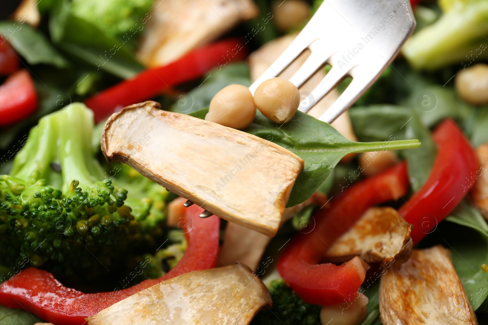 Eating tasty salad with eryngium mushrooms on blurred background, closeup Photo of Eating tasty salad with eryngium mushrooms on blurred background, closeup