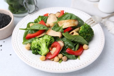 Photo of Tasty salad with eryngium mushrooms, chickpeas, vegetables and spinach on light table, closeup