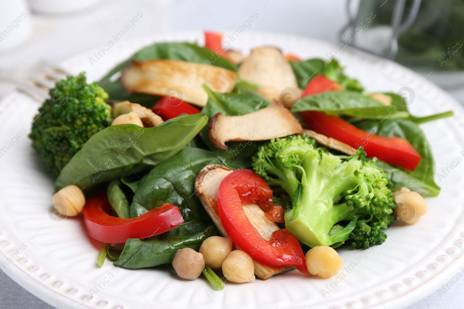 Tasty salad with eryngium mushrooms, chickpeas, vegetables and spinach on table, closeup Photo of Tasty salad with eryngium mushrooms, chickpeas, vegetables and spinach on table, closeup