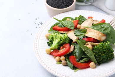 Photo of Tasty salad with eryngium mushrooms, chickpeas, vegetables and spinach on light table, closeup. Space for text