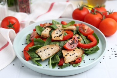 Photo of Tasty salad with eryngium mushrooms, vegetables, spinach and sesame on white table, closeup