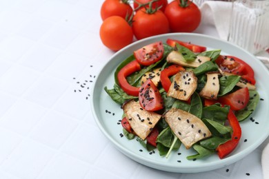 Photo of Tasty salad with eryngium mushrooms, vegetables, spinach and sesame on white tiled table, closeup. Space for text