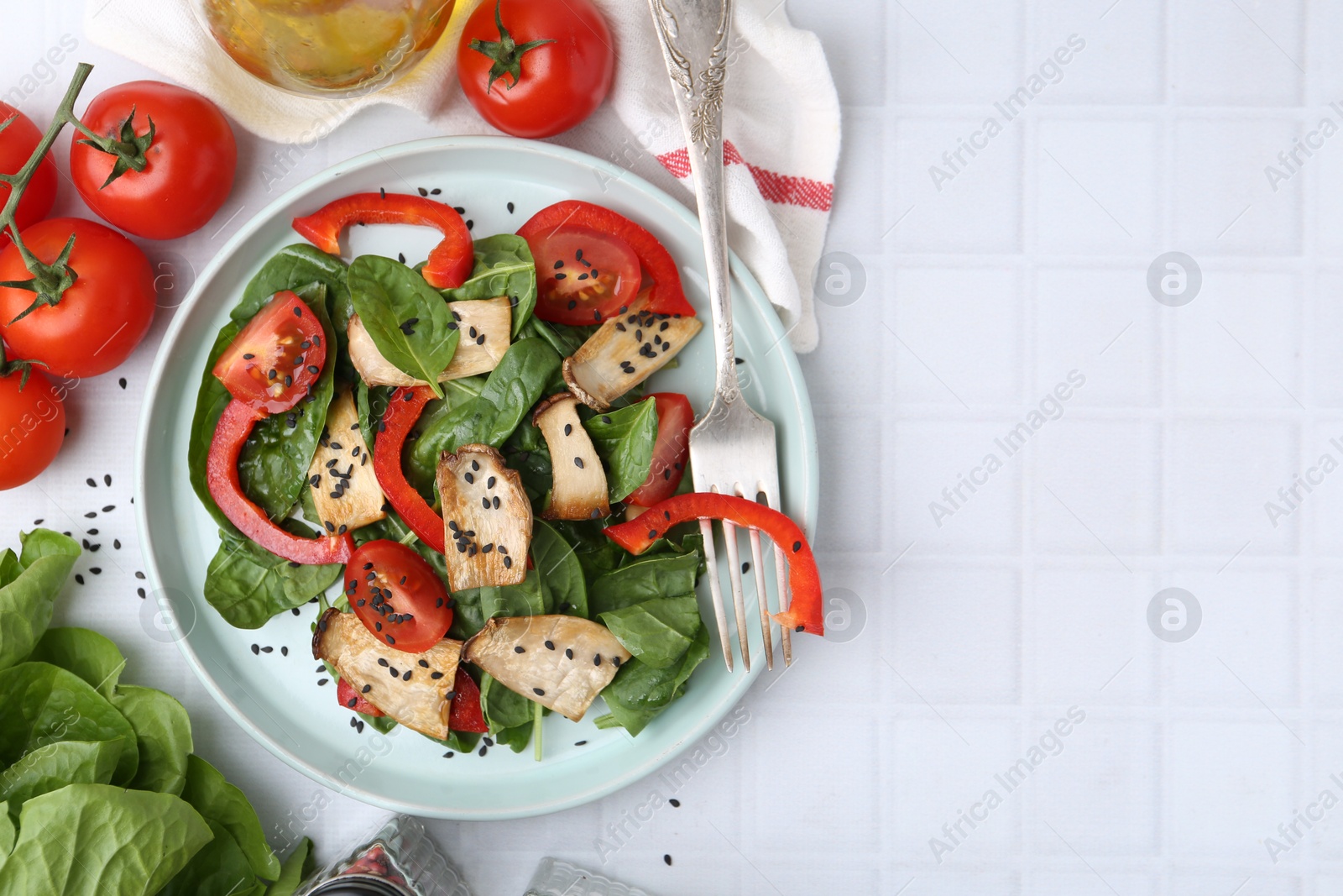 Tasty salad with eryngium mushrooms served on white tiled table, flat lay. Space for text Photo of Tasty salad with eryngium mushrooms served on white tiled table, flat lay. Space for text