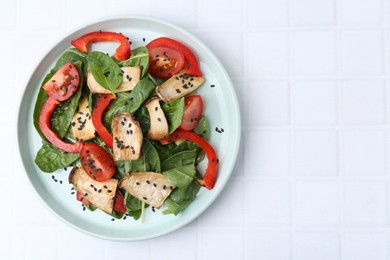 Photo of Tasty salad with eryngium mushrooms, vegetables, spinach and sesame on white tiled table, top view. Space for text