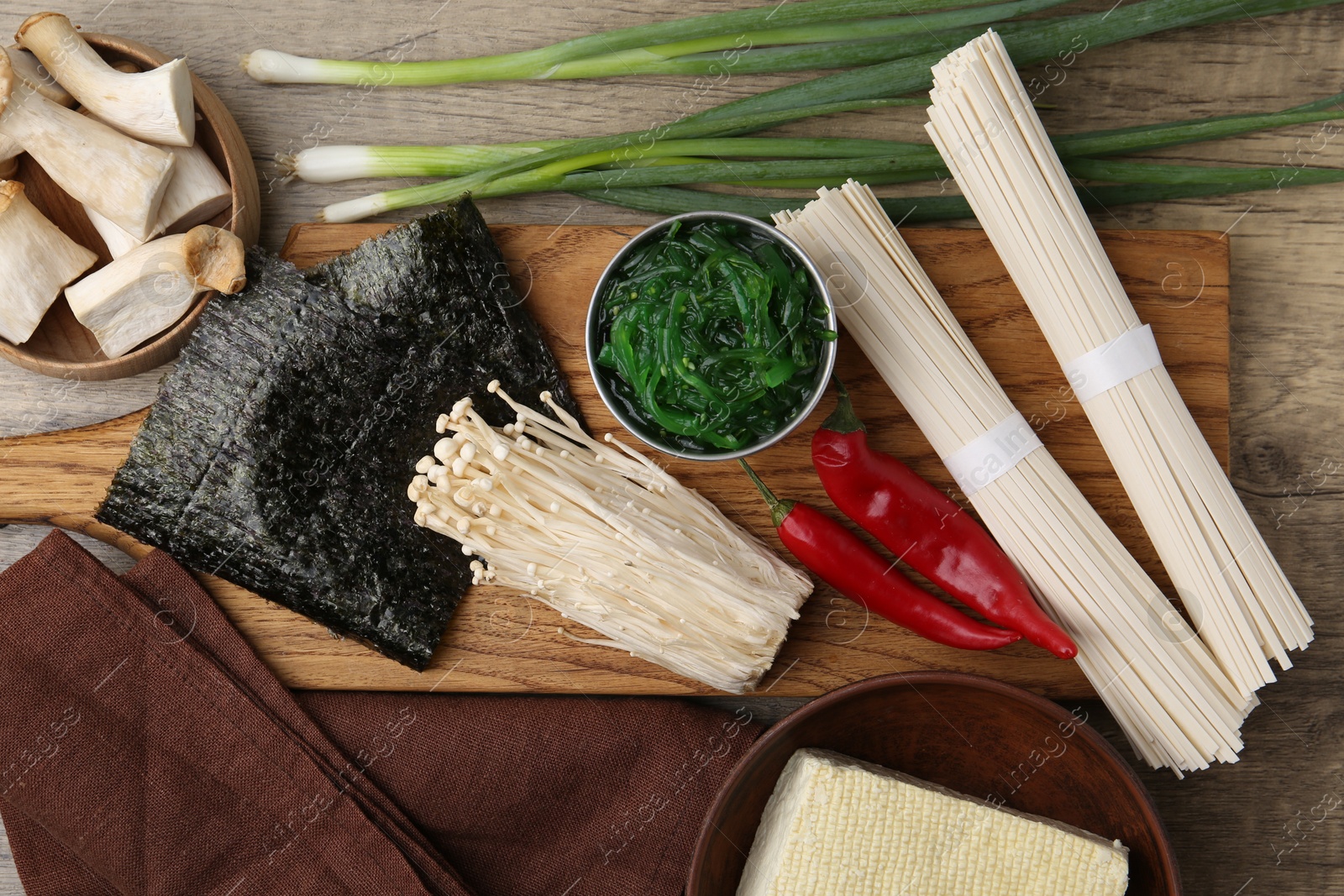 Photo of Enoki, king oyster (eryngii) mushrooms and other ingredients for ramen on table, flat lay