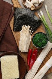 Photo of Enoki, king oyster (eryngii) mushrooms and other ingredients for ramen on table, flat lay