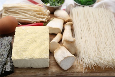 Photo of Enoki, king oyster (eryngii) mushrooms and other ingredients for ramen on table, closeup