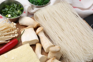 Photo of Enoki, king oyster (eryngii) mushrooms and other ingredients for ramen on table, closeup