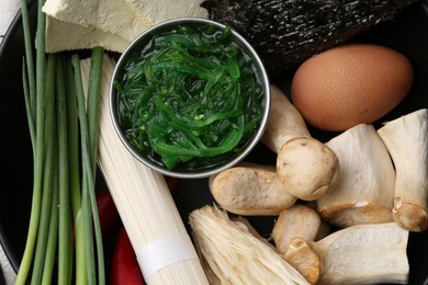 Photo of Enoki, king oyster (eryngii) mushrooms and other ingredients for ramen in bowl, top view
