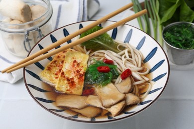 Photo of Tasty ramen with king oyster (eryngii) mushrooms in bowl on light table, closeup