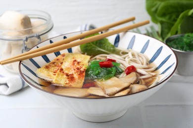 Photo of Tasty ramen with king oyster (eryngii) mushrooms in bowl on light table, closeup