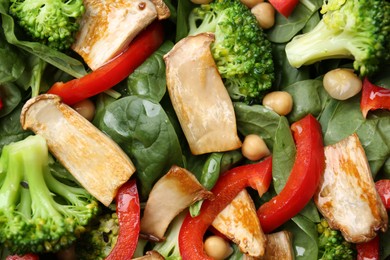 Photo of Tasty salad with eryngium mushrooms, chickpeas, vegetables and spinach as background, top view