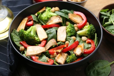 Photo of Tasty salad with eryngium mushrooms served on wooden table, closeup