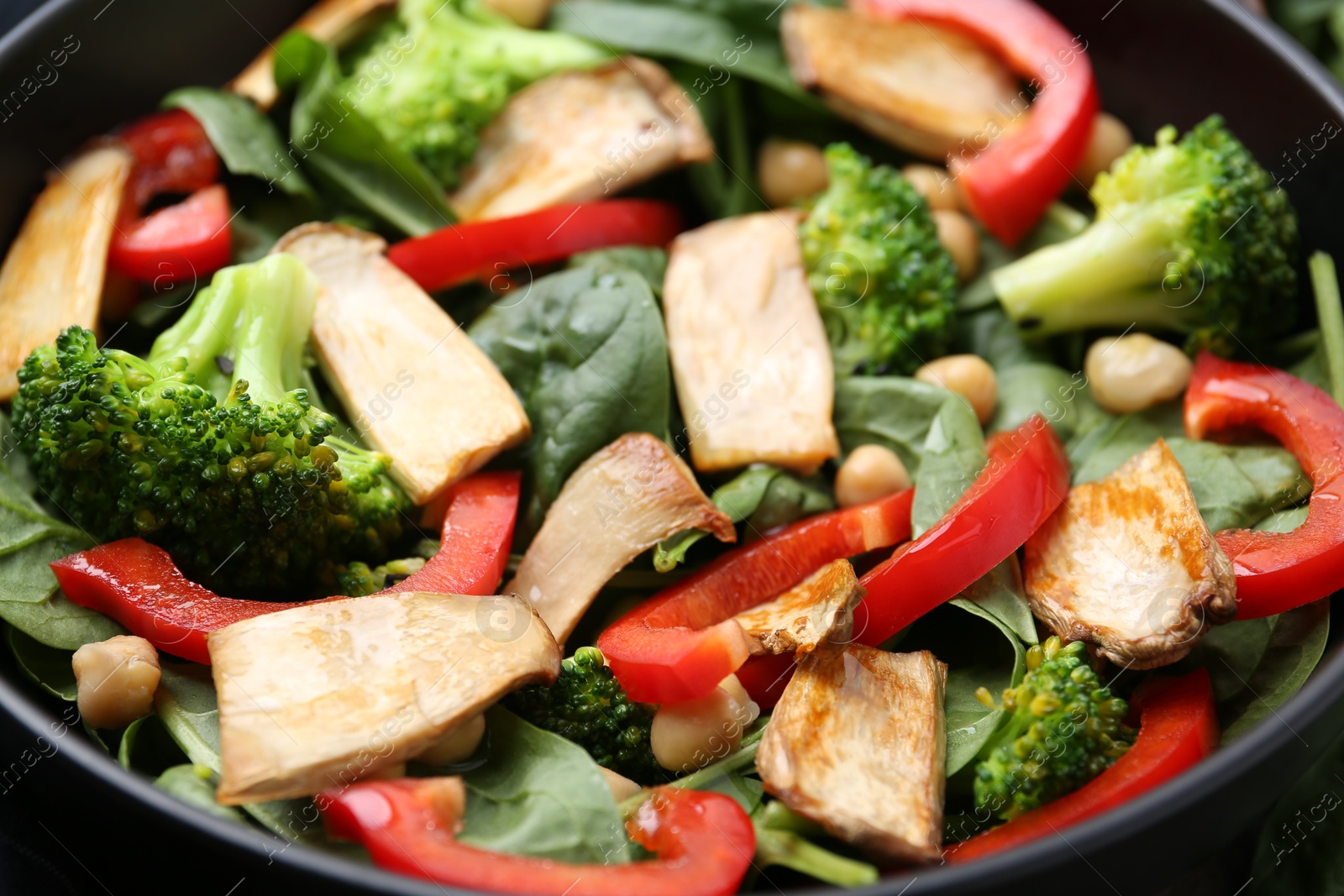Tasty salad with eryngium mushrooms, chickpeas, vegetables and spinach in bowl, closeup Photo of Tasty salad with eryngium mushrooms, chickpeas, vegetables and spinach in bowl, closeup