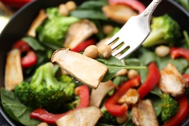 Photo of Eating tasty salad with eryngium mushrooms on blurred background, closeup