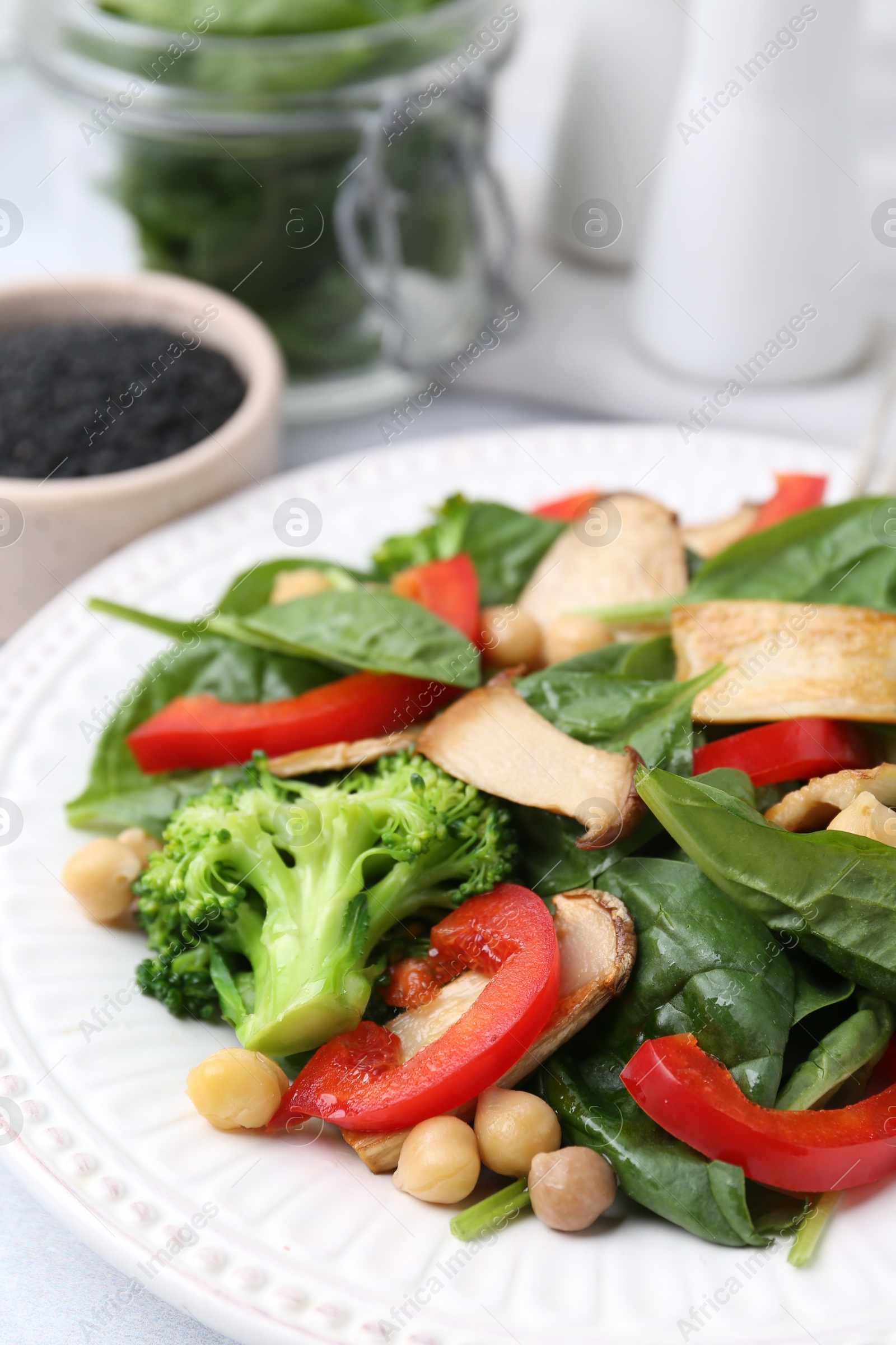 Tasty salad with eryngium mushrooms, chickpeas, vegetables and spinach on table, closeup Photo of Tasty salad with eryngium mushrooms, chickpeas, vegetables and spinach on table, closeup