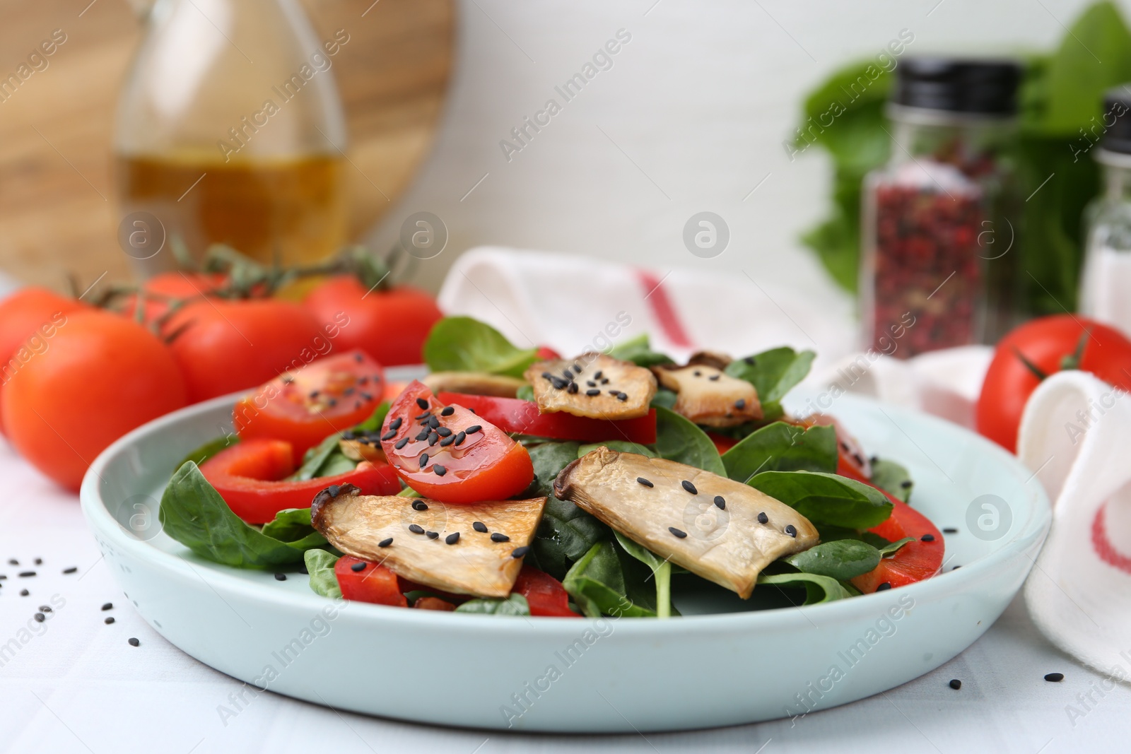 Tasty salad with eryngium mushrooms, vegetables, spinach and sesame on white table, closeup Photo of Tasty salad with eryngium mushrooms, vegetables, spinach and sesame on white table, closeup
