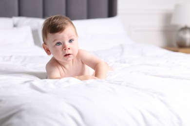 Photo of Cute little baby on bed indoors, space for text