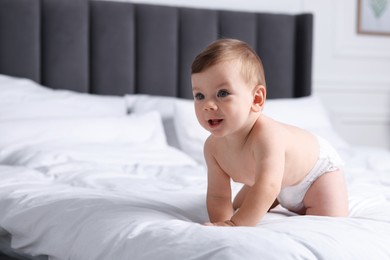 Photo of Cute little baby on bed at home, space for text