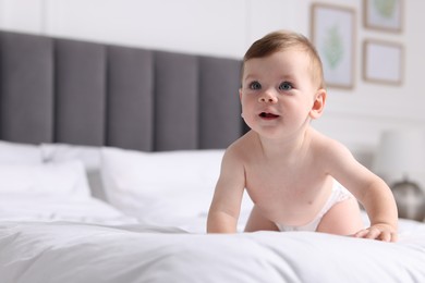 Photo of Cute little baby on bed at home, space for text