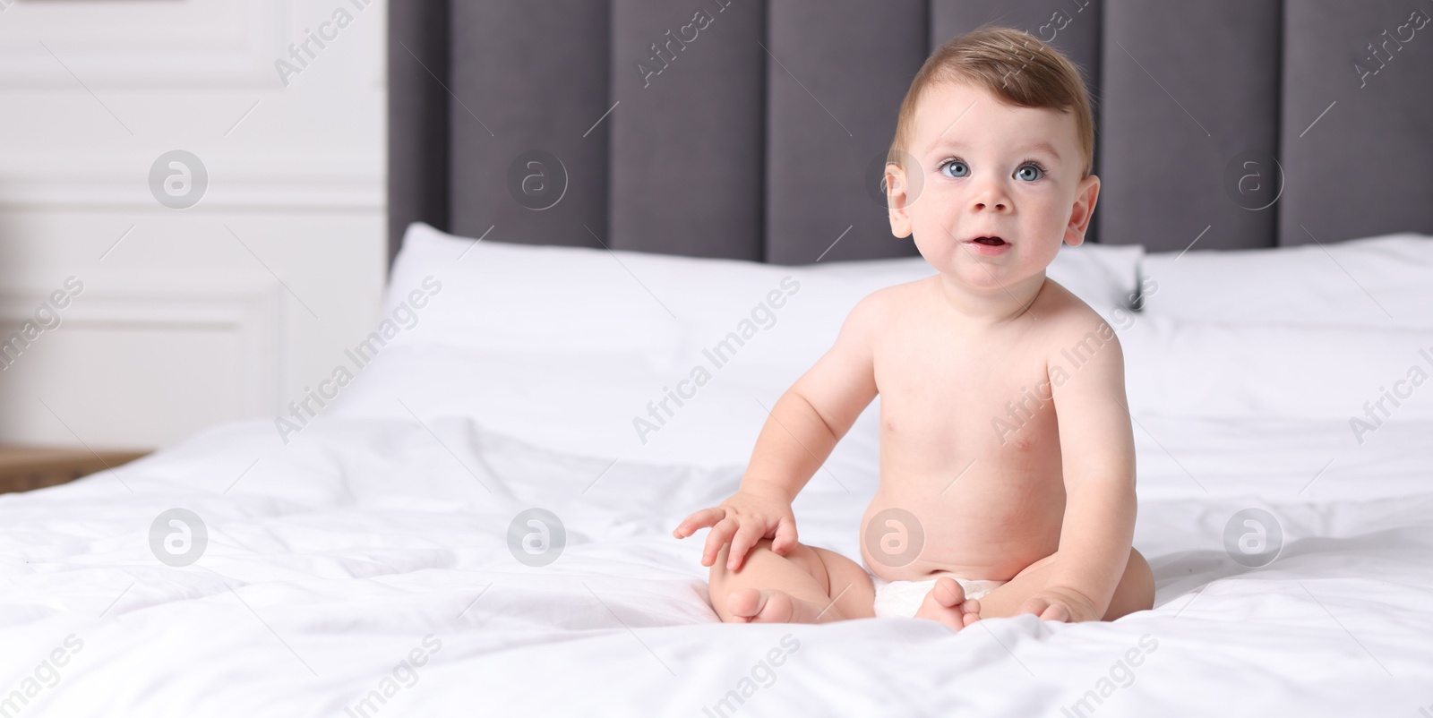 Photo of Cute little baby on bed at home, space for text
