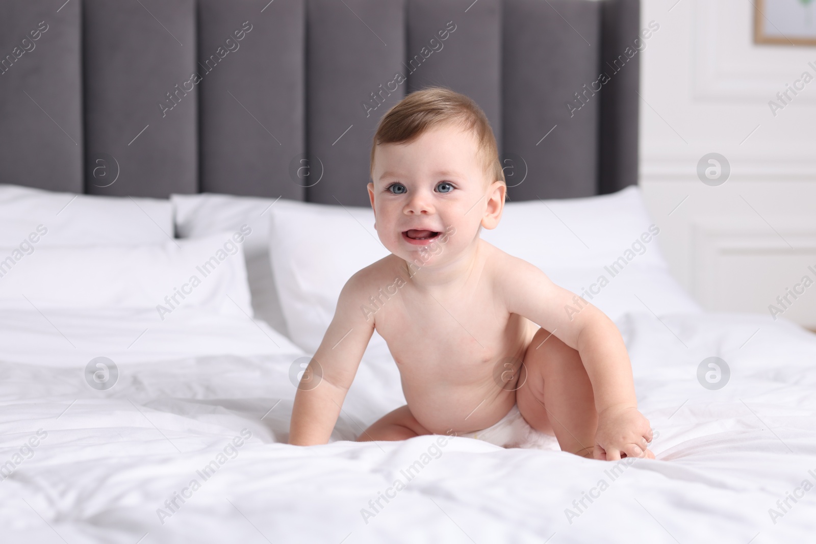 Photo of Cute little baby on bed at home, space for text