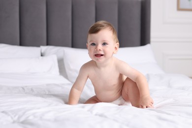Photo of Cute little baby on bed at home, space for text